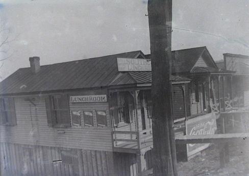 Lunchroom at Monroe.  This burned some time after 1912.  On south side across from Hicks store; station to the right